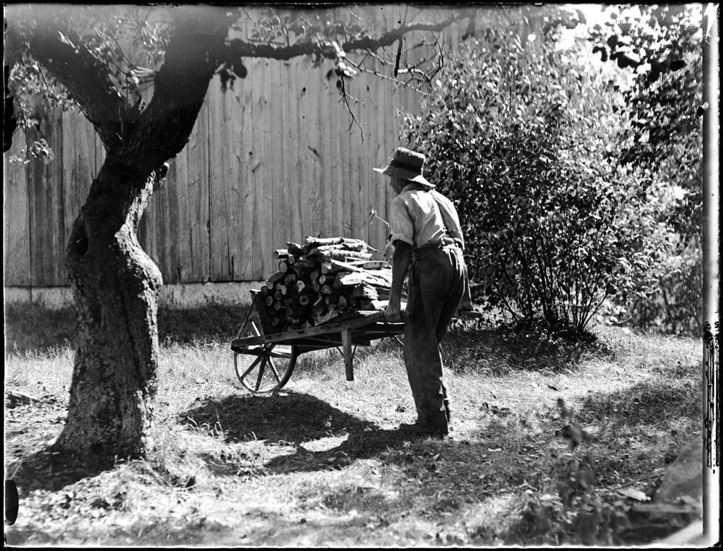 Miniature of Man Pushing A Wheelbarrow Full Of Firewood