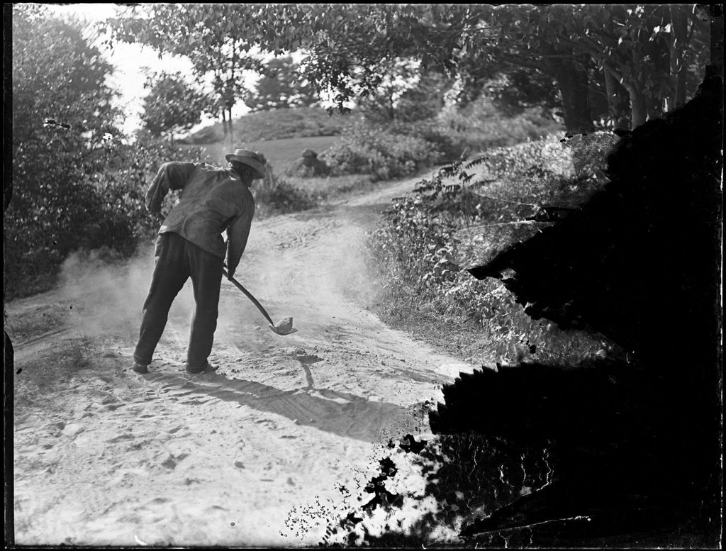 Miniature of Man Shoveling Gravel Beside A Road