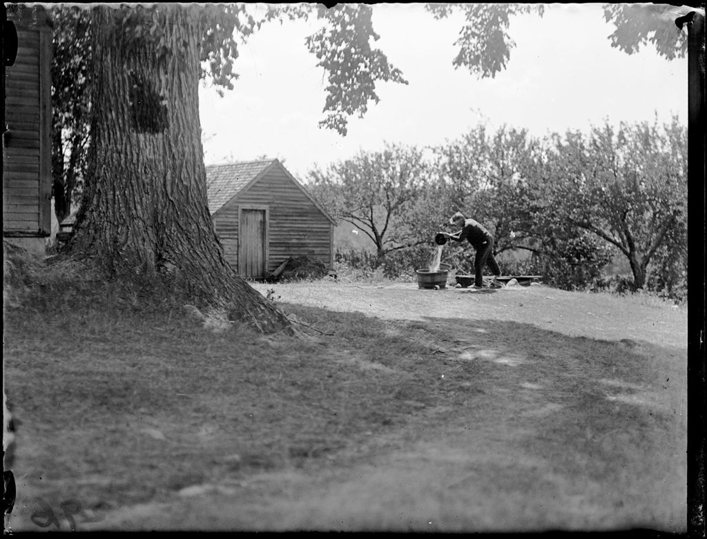 Miniature of Person Filling A Tub With Water From A Well Outside A Rural Home