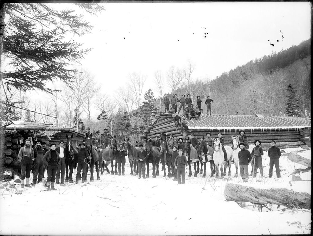 Miniature of Snow covered winter scene of many men and horses at a logging camp