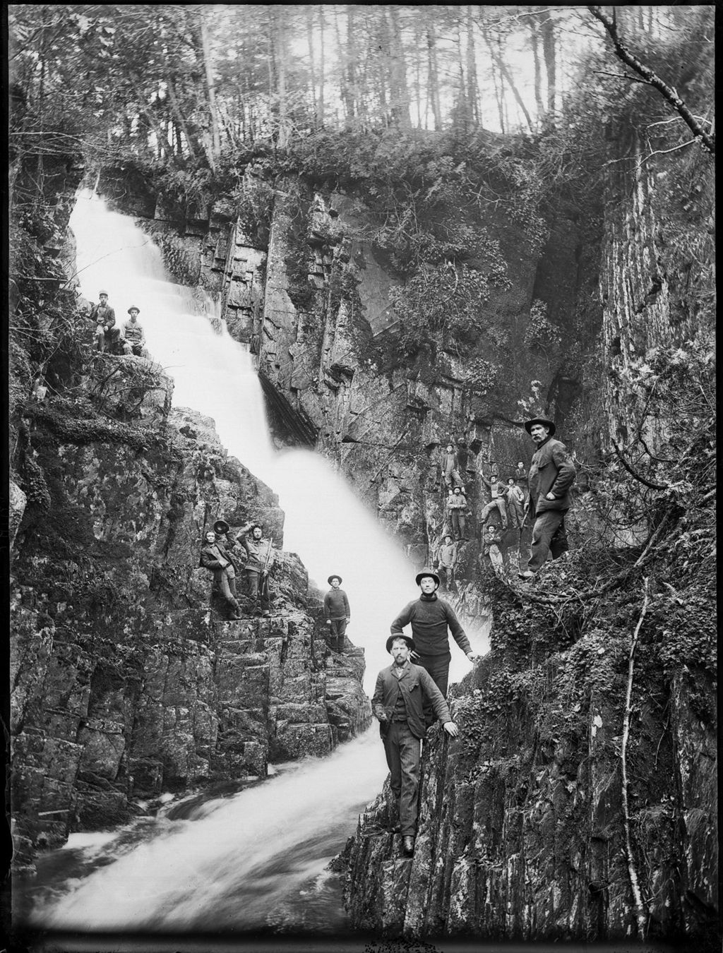 Miniature of Men standing on the steep rock banks of a rushing downhill flowing river