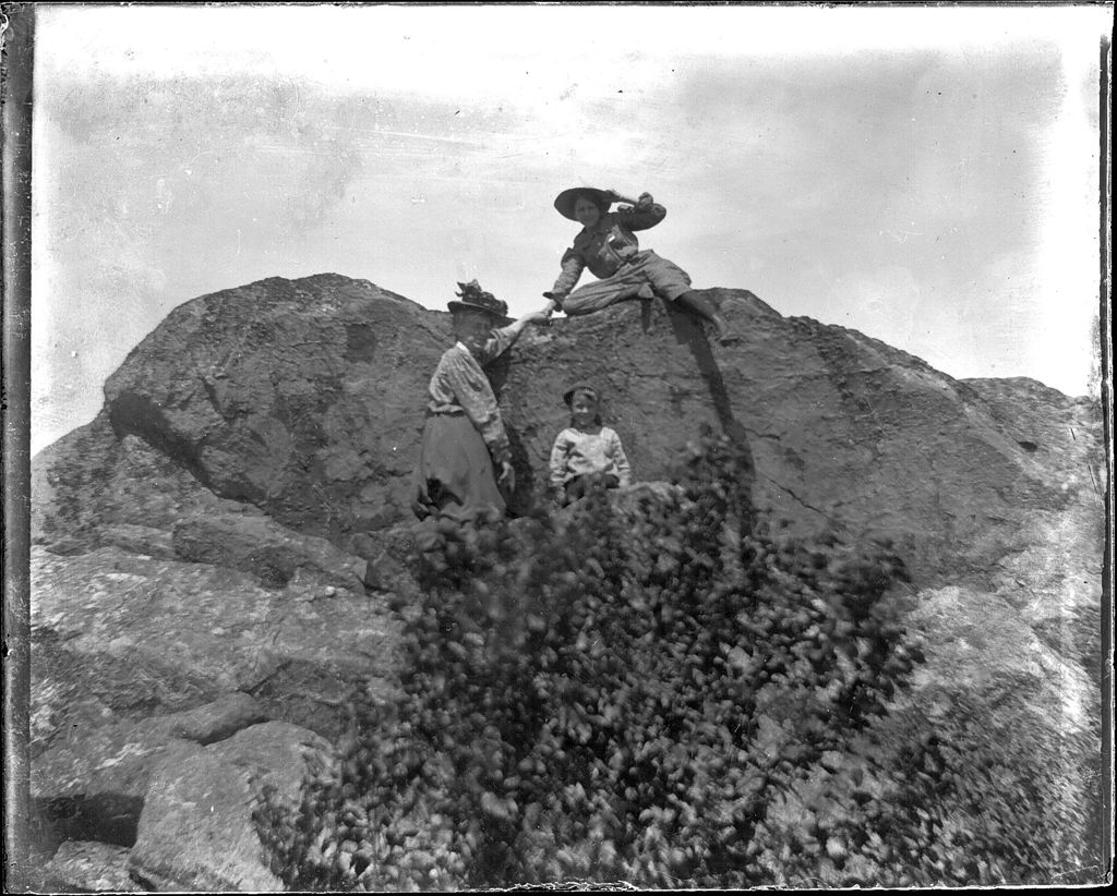 Miniature of Two women and a young boy standing atop a rocky outcrop