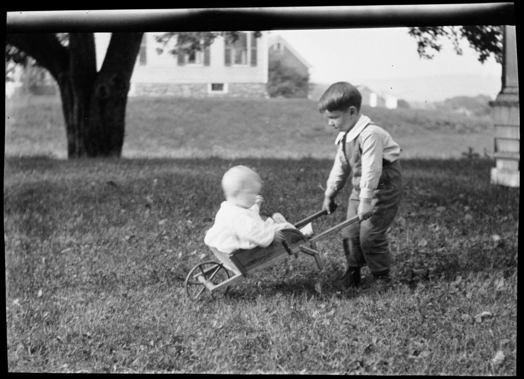 Miniature of Tots- Boy Hauls Baby In Little Red Wheel Barrow