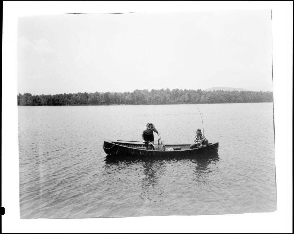 Miniature of Two Men Fishing From A Boat In The Middle Of A Lake, One Netting Fish