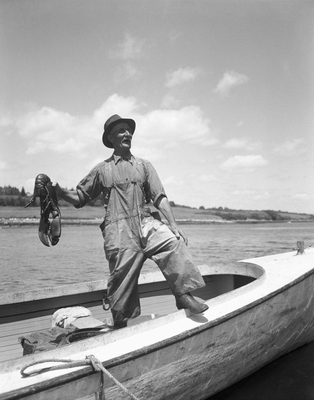 Miniature of Lobster Fisherman In New Harbor Standing In A Boat, He Is Holding Up One Big Lobster
