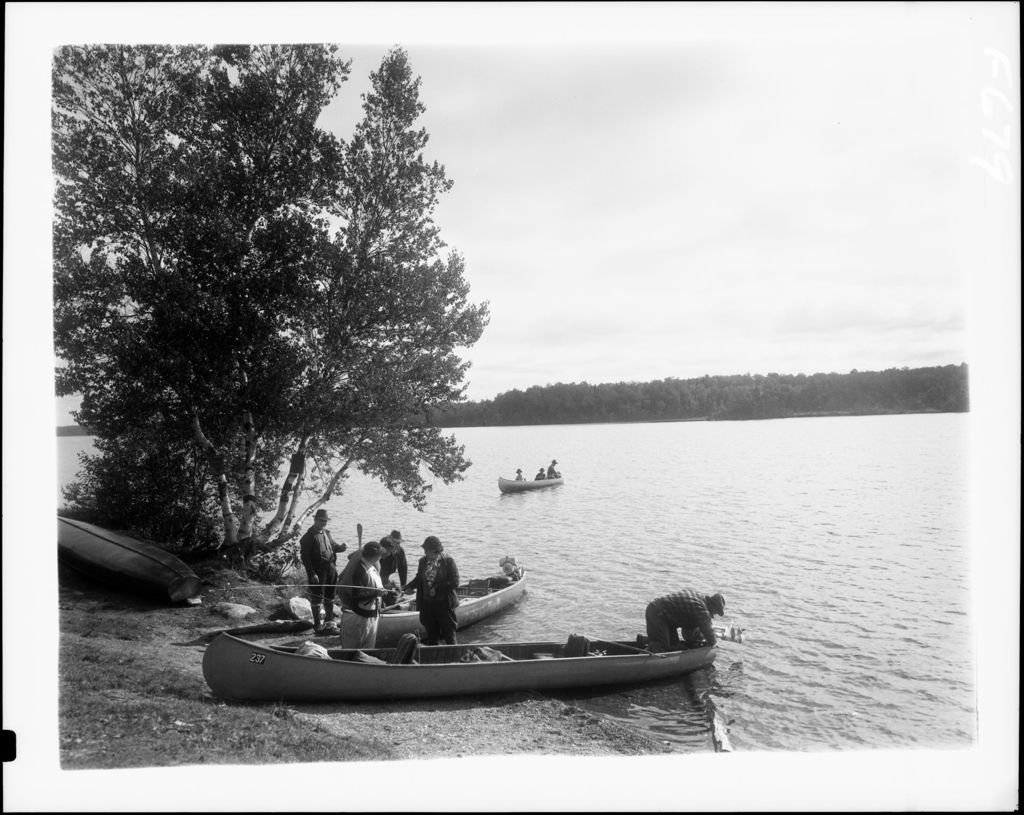 Miniature of People Standing Around A Couple Of Canoes At Edge Of Big Lake Preparing To Go Fishing