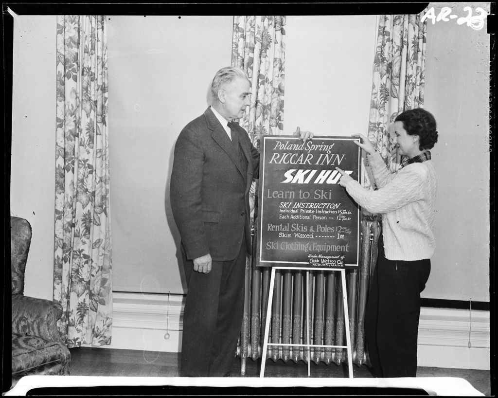 Miniature of Man And Woman Standing Beside A Sign Advertising Ski Instruction At Riccar Inn