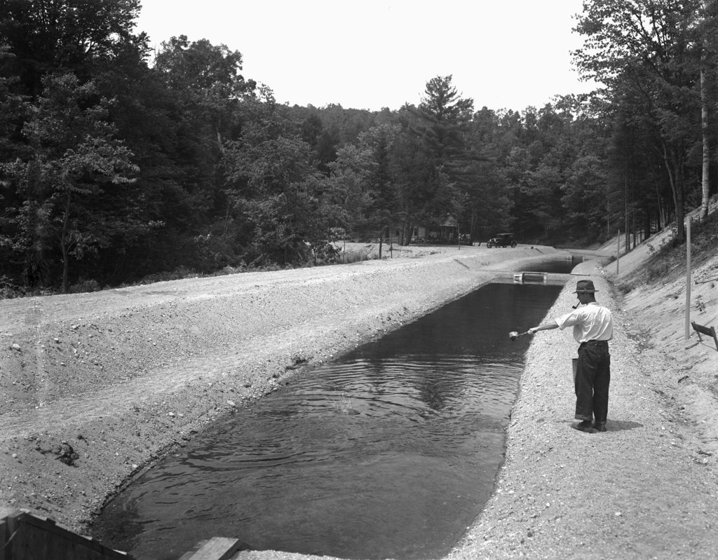 Miniature of Two Men Standing Near A Fish Hatchery Canal In Lovell