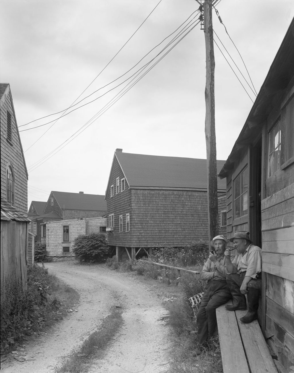 Miniature of Two Men Smoking Pipes While Sitting In The Doorway Of A Shop In Ogunquit