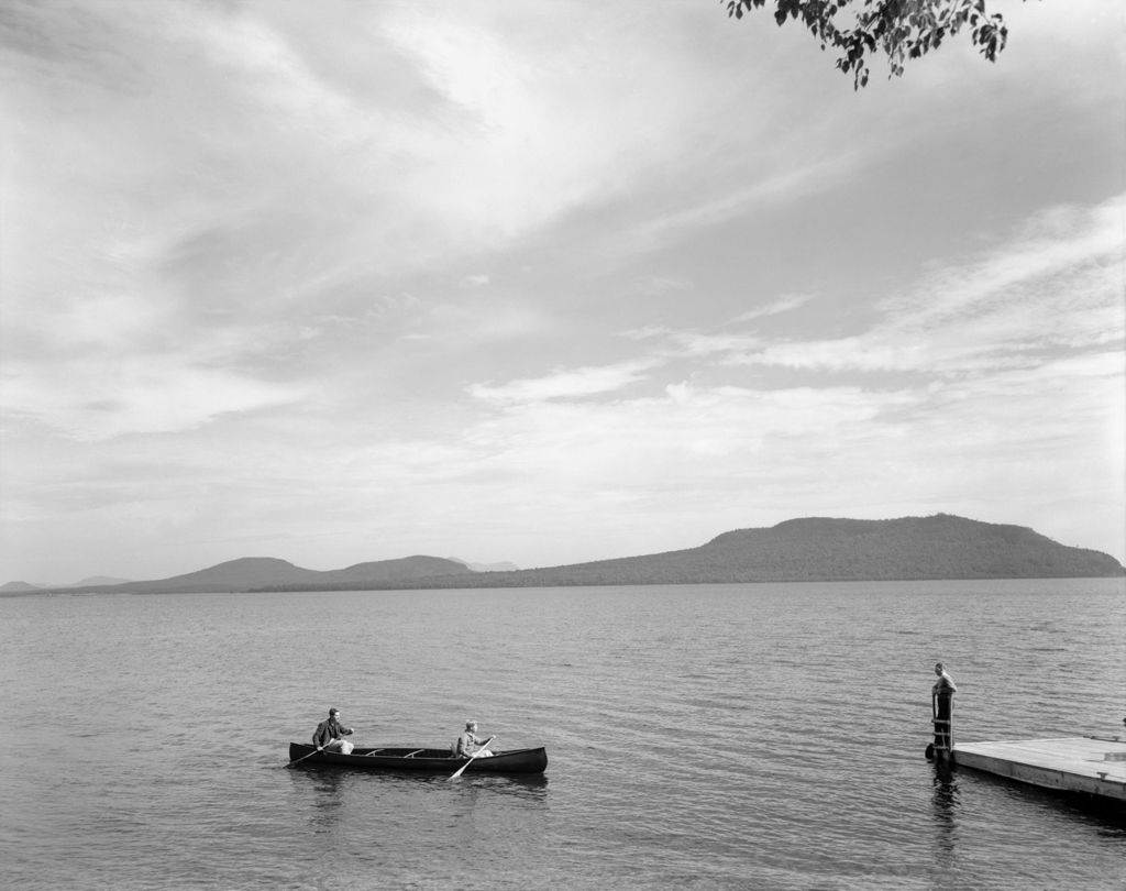 Miniature of Two Men In Canoe Paddle To Dock, Man Stands There, Mountains Afar At Moosehead