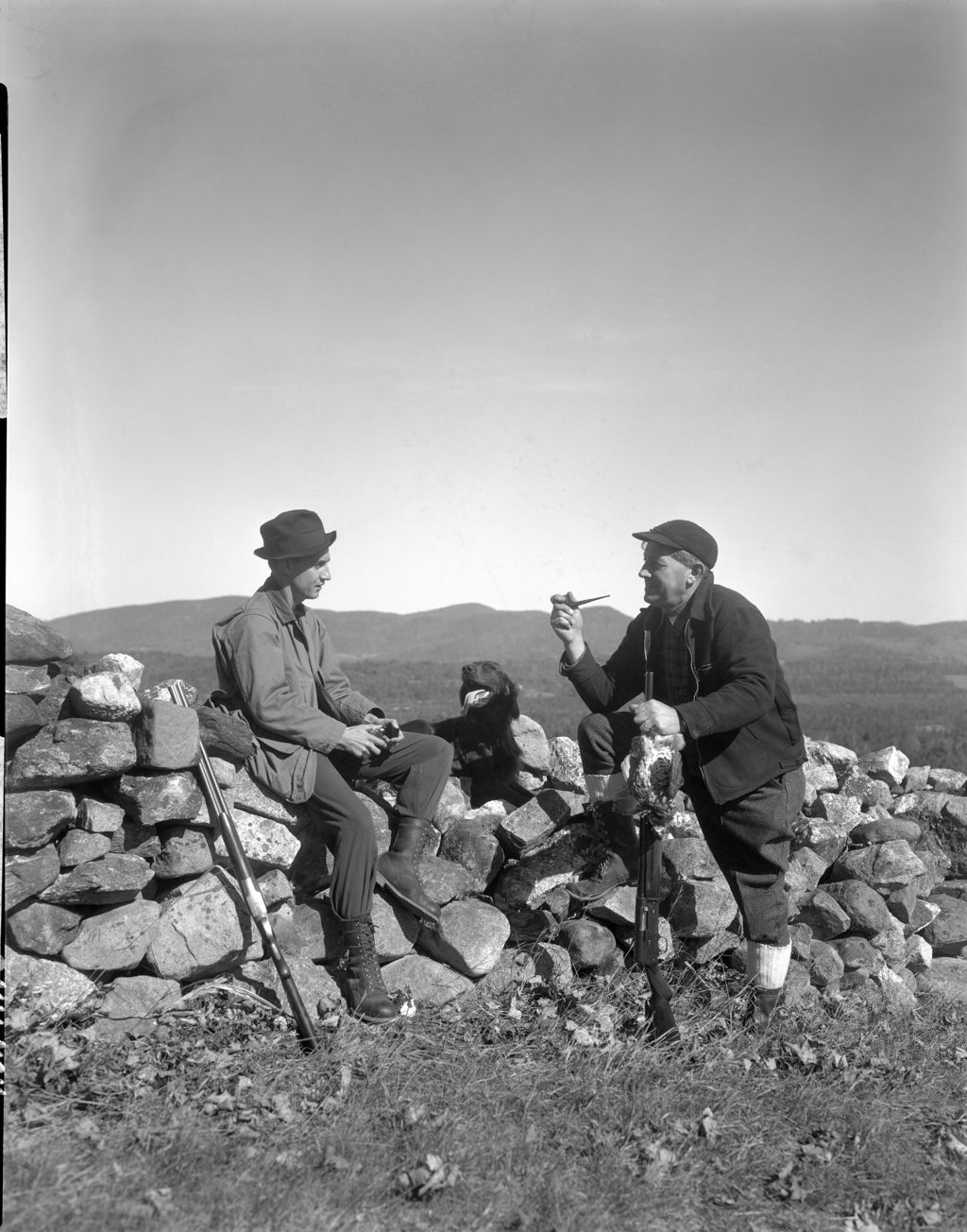 Miniature of Two Partridge Hunters And A Dog Sitting On A Stone Wall With Nice View Of Mountains