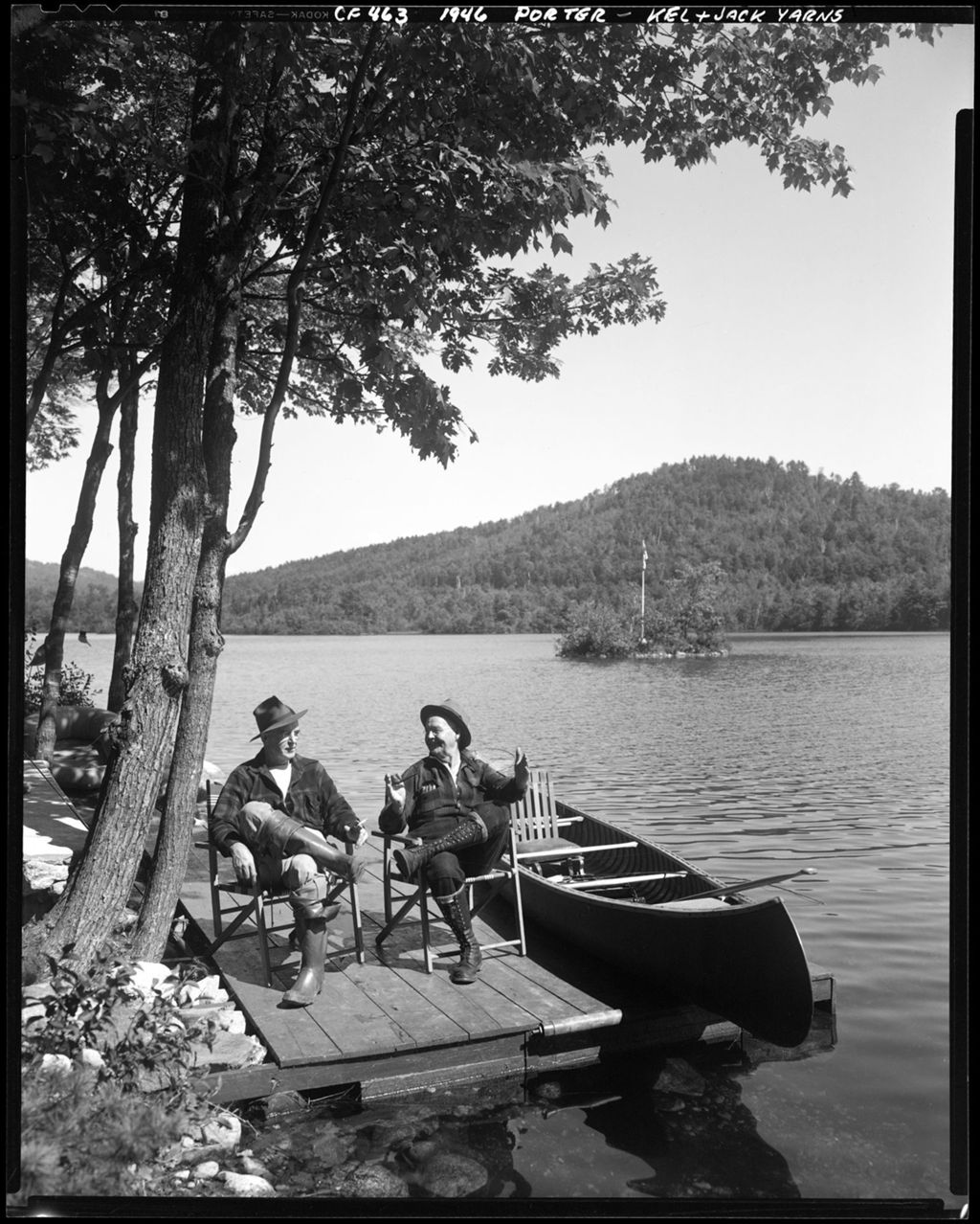 Miniature of Two Men Sitting On A Dock Under A Tree In Porter, Lake And Mountains In Background