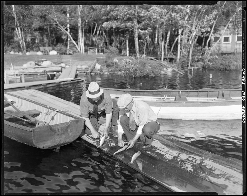 Miniature of Two Men Standing On A Pier Cleaning The Days Catch On Sebago Lake