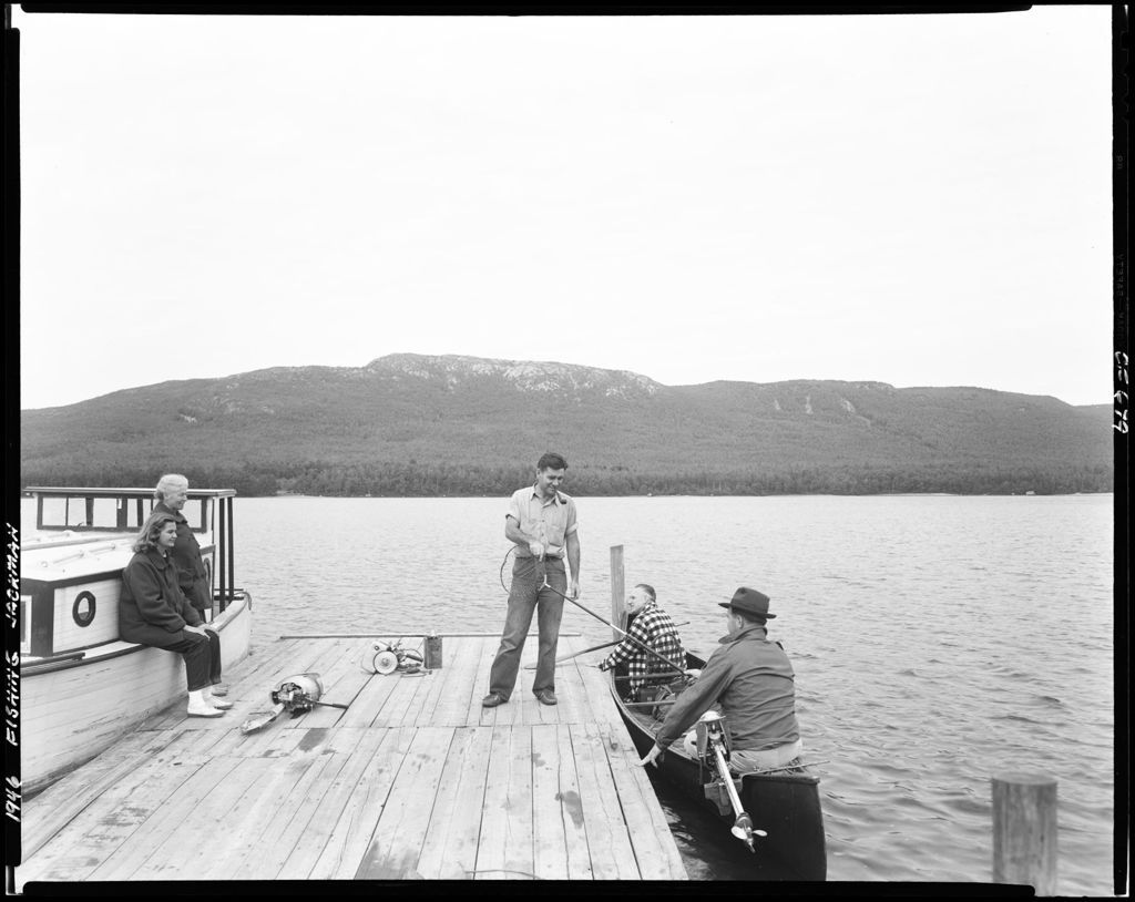 Miniature of Two Men In A Canoe Against Dock Talking To Man On Dock