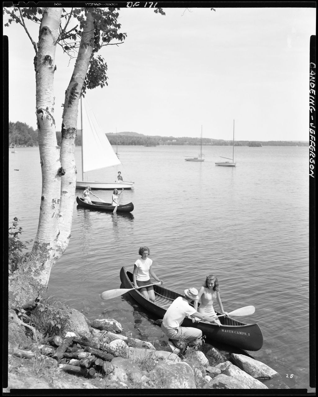 Miniature of Man On Shore Steadying Canoe With Two Women In It, Other Canoes And Sailboat In Background At Jefferson