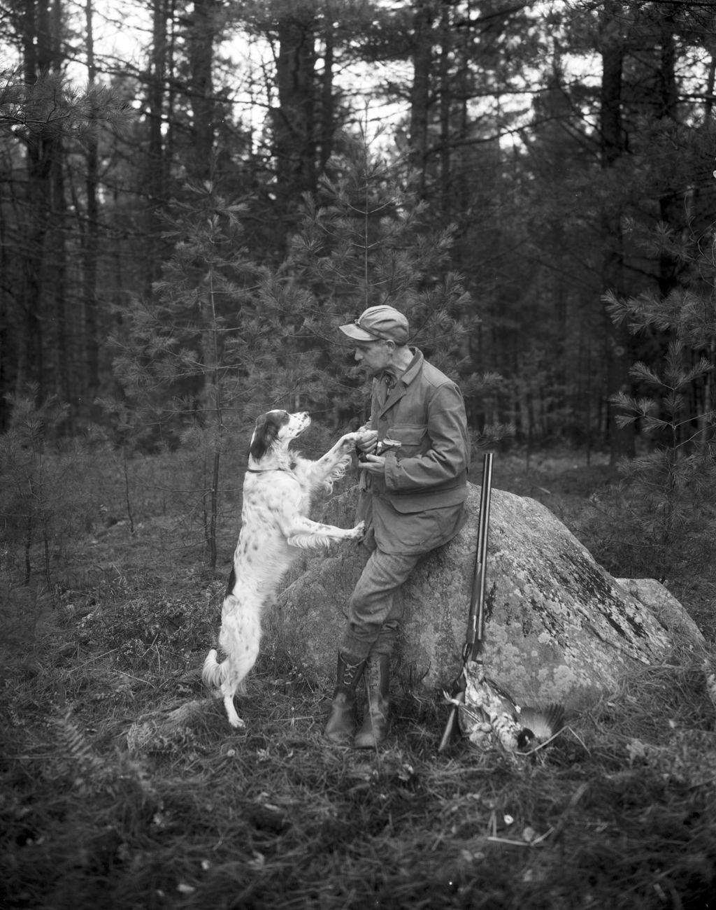 Miniature of Hunter And His Dog Standing Beside A Large Rock