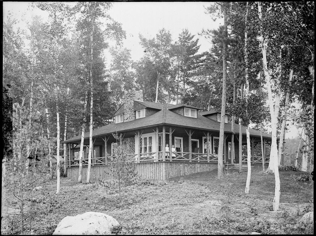 Miniature of Two children standing on the covered veranda of a home in a wooded area