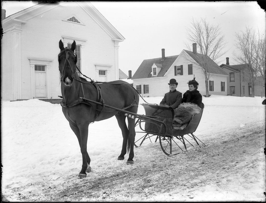 Miniature of Man and woman in a horse drawn sled on a snow covered town street