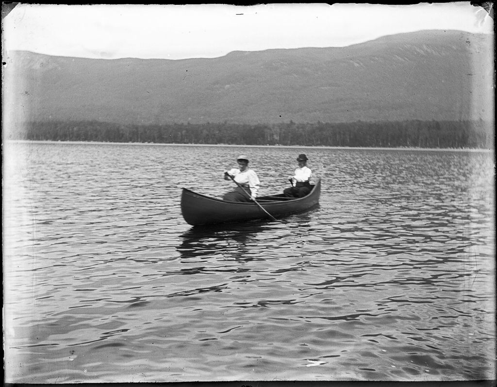 Miniature of Two people in a canoe on a lake, hills in the distance